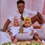 Romain Virgo poses with his twin daughters during a photoshoot.