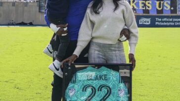 Andre Blake shows off his MLS Goalkeeper of the Year Award alongside his family