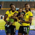 Konya Plummer and Cheyna Matthews pose with their children at the National Stadium in Kingston.