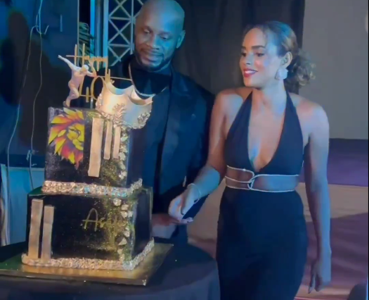 Asafa Powell cuts his 40th birthday cake alongside his wife, Alyshia Miller Powell