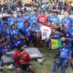 Jamaica College players and coaches celebrate after winning the 2022 Manning Cup