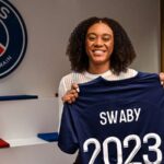 Allyson Swaby holds up her jersey as she signs her contract with Ligue 1 Feminines side, Paris St. Germain