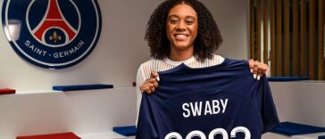 Allyson Swaby holds up her jersey as she signs her contract with Ligue 1 Feminines side, Paris St. Germain