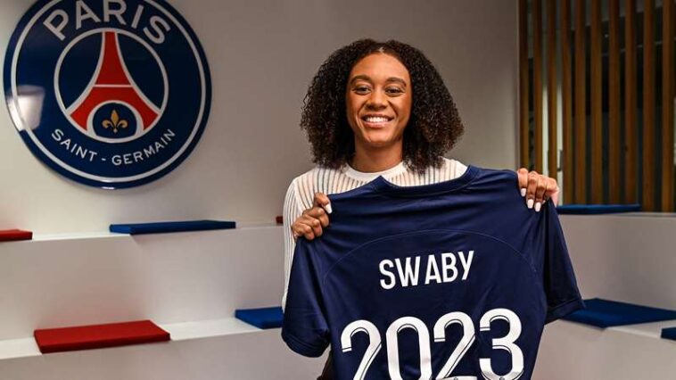Allyson Swaby holds up her jersey as she signs her contract with Ligue 1 Feminines side, Paris St. Germain