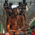 Masicka poses with women in police gear during music video for "Tyrant."