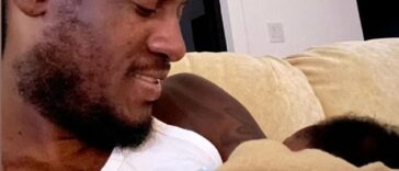 Aidonia holds his son at his home in Kingston