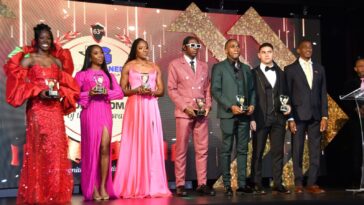 Shericka Jackson (far left) and Antonio Watson (middle) hold their respective RJR/Gleaner Sportswoman and Sportsman of the Year trophies.