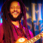 Julian Marley performs on his guitar during a show.