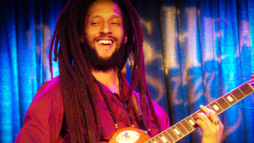 Julian Marley performs on his guitar during a show.