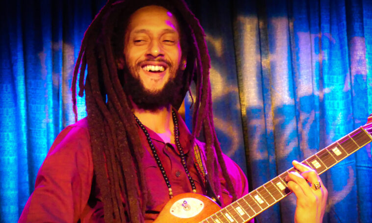 Julian Marley performs on his guitar during a show.