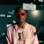Masicka is surrounded by money in his new video for "Reverse Time."