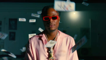 Masicka is surrounded by money in his new video for "Reverse Time."