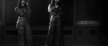 Lila Ike and H.E.R. pose during their music video for 'He Loves Us Both.'