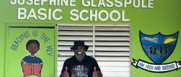 Chris Gayle stands in front of the Josephine Glasspole Basic School.