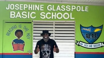 Chris Gayle stands in front of the Josephine Glasspole Basic School.