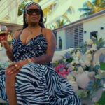 Shaneil Muir sips win in her new music video for Secured.