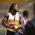 Kishane Thompson celebrates with flowers after winning men's 100m at the 2025 Racers Grand Prix