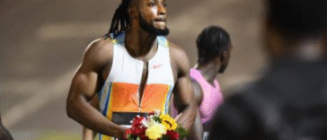 Kishane Thompson celebrates with flowers after winning men's 100m at the 2025 Racers Grand Prix