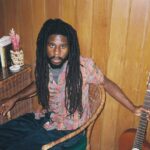 Chronixx poses with a guitar in a studio to promote his new album, "Exile."