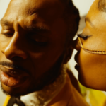 Dexta Daps gets close with a lady during the "Champagne" music video.