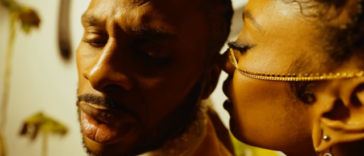 Dexta Daps gets close with a lady during the "Champagne" music video.