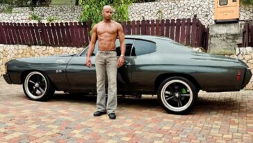 Asafa Powell, an avid car collector, poses with his vintage vehicle