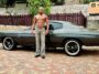 Asafa Powell, an avid car collector, poses with his vintage vehicle