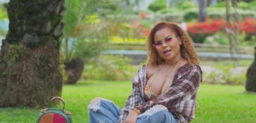 Ce'Cile sits in the park during the music video for "Baddest Love"