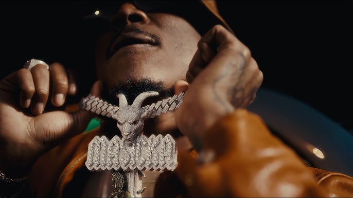 Masicka shows off his GOAT chain during the music video for "Boasty."