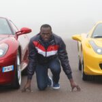 Usain Bolt gets on his mark in between two luxury Ferrari vehicles.