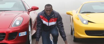 Usain Bolt gets on his mark in between two luxury Ferrari vehicles.