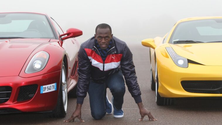 Usain Bolt gets on his mark in between two luxury Ferrari vehicles.
