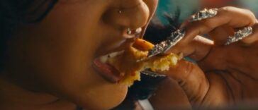 Stalk Ashley eats chicken during a scene in her 'Quaker' music video