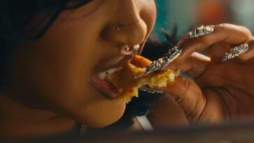 Stalk Ashley eats chicken during a scene in her 'Quaker' music video
