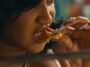Stalk Ashley eats chicken during a scene in her 'Quaker' music video