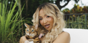 Shenseea pets a cat in her music video for 'Tightness.'